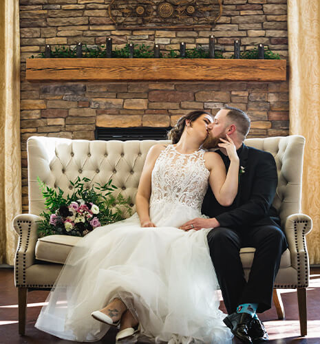 bride groom kissing by fireplace