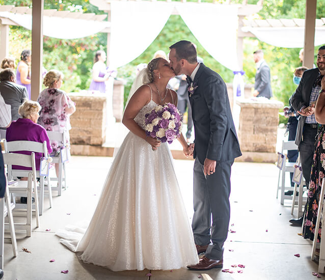 bride groom kissing ceremony aisle