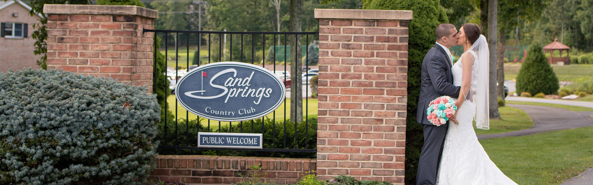 bride groom kissing sand springs sign