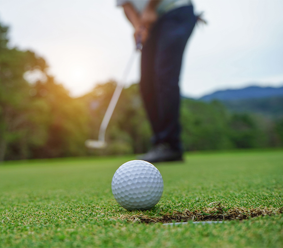 golfer putting ball hole